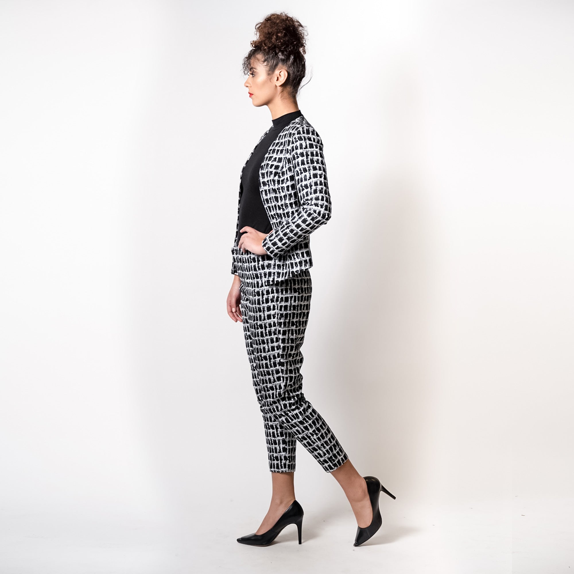 Woman wearing a black and white patterned outfit on a plain background