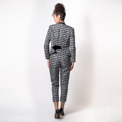 Person wearing a black and white patterned suit on a white background