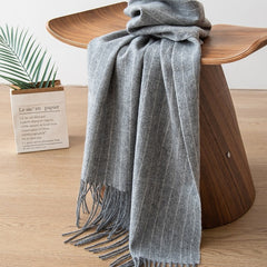 Gray scarf draped over a wooden chair with a minimal background