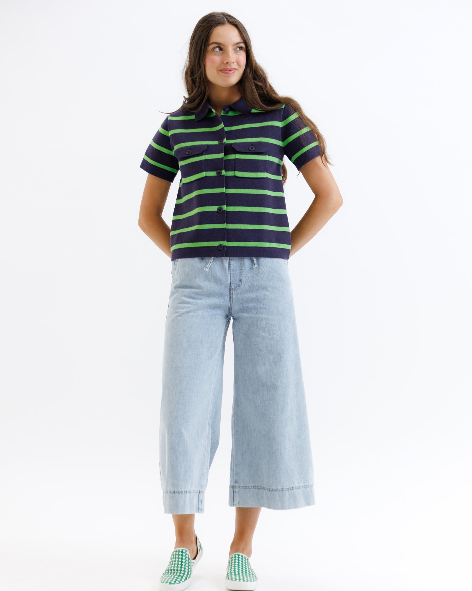 Woman wearing a striped shirt and light blue jeans on a white background