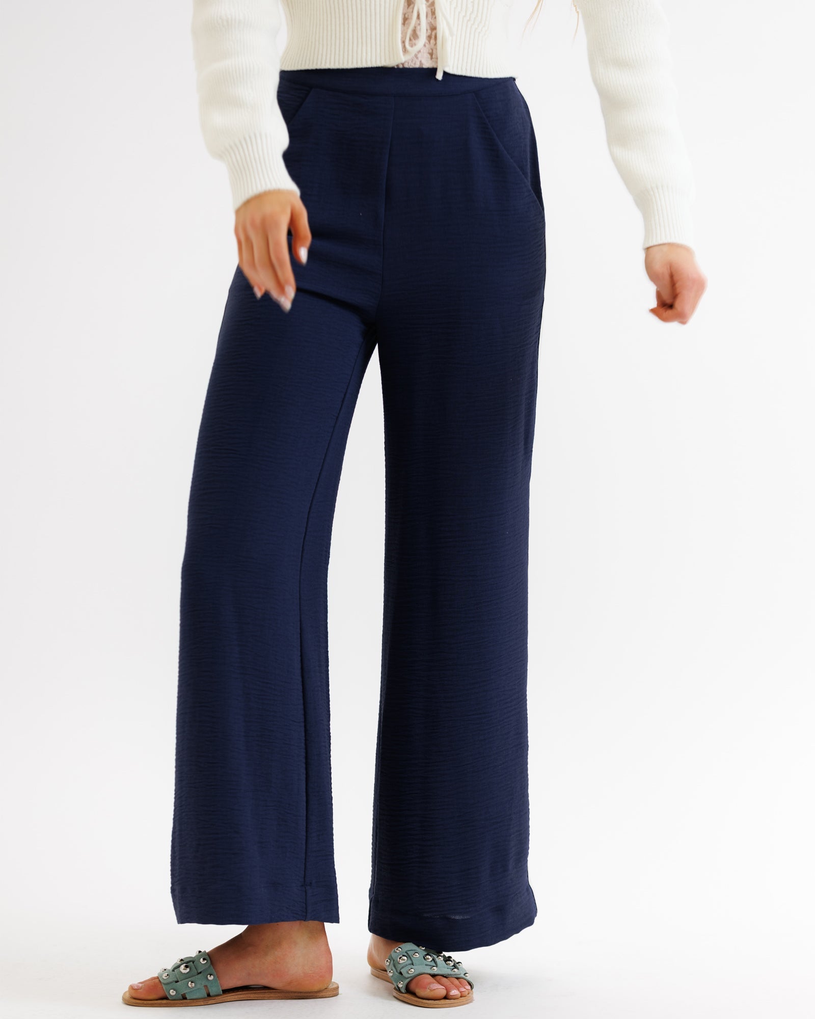 Navy blue wide-leg pants worn by a person on a white background