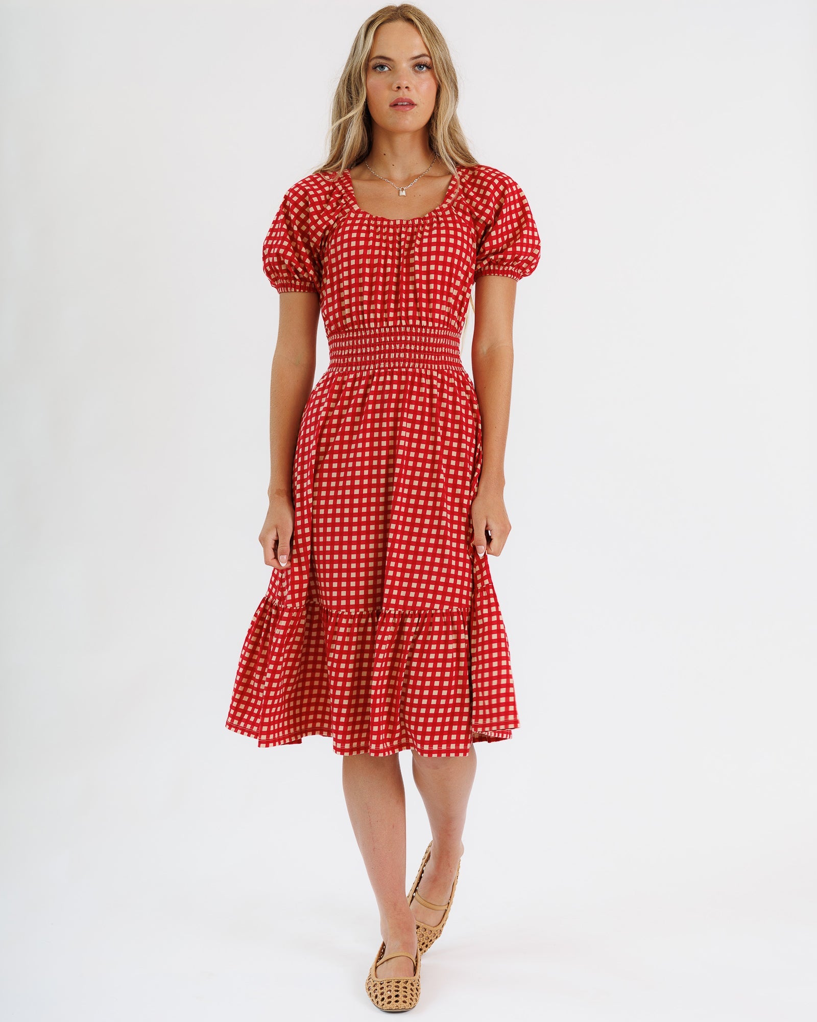 Woman wearing a red checkered dress on a white background