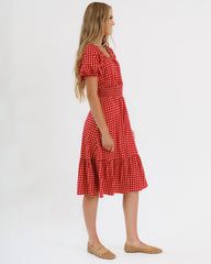 Woman wearing a red polka dot dress on a white background