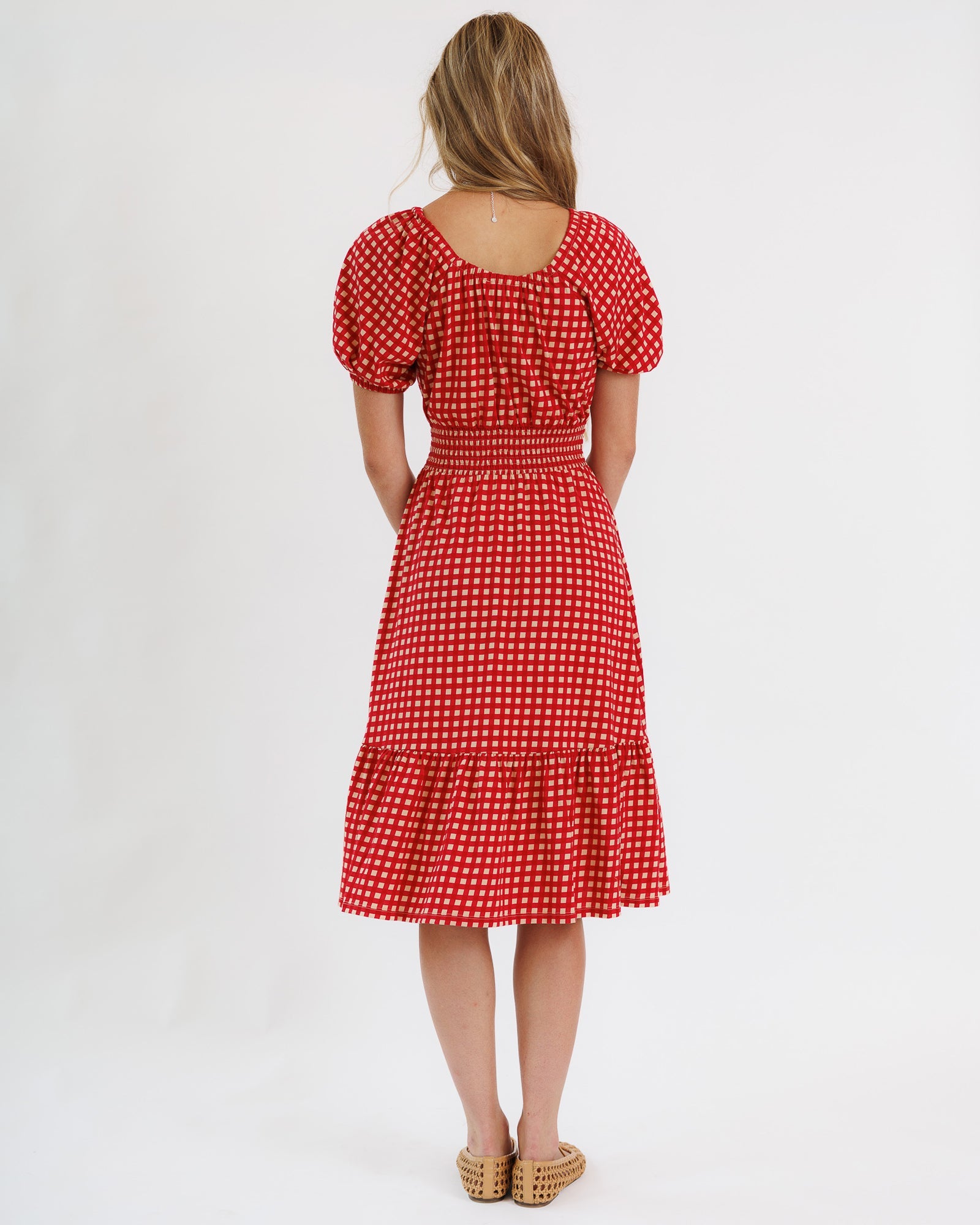 Red polka dot dress worn by a person on a white background