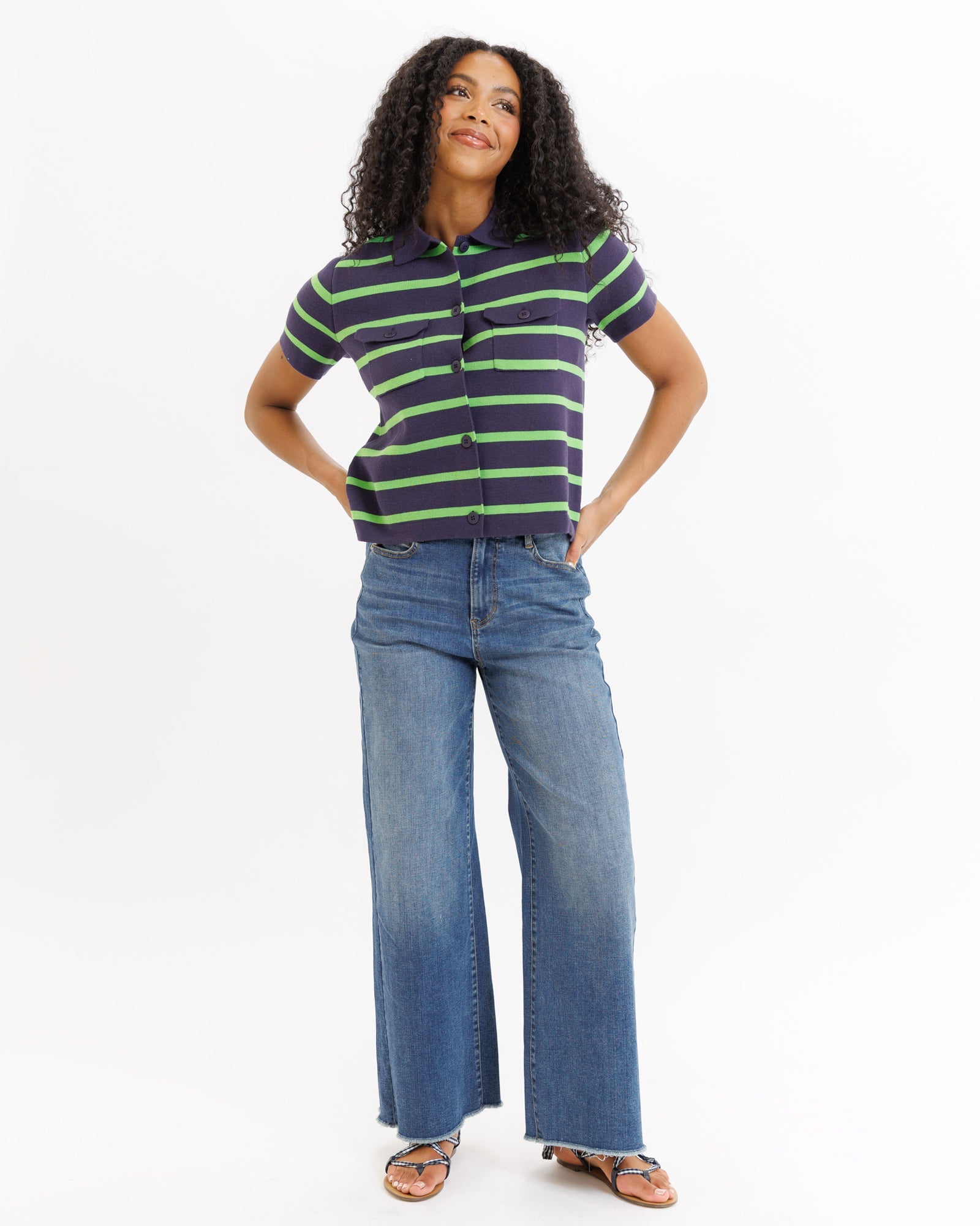 Woman wearing a striped shirt and jeans on a white background