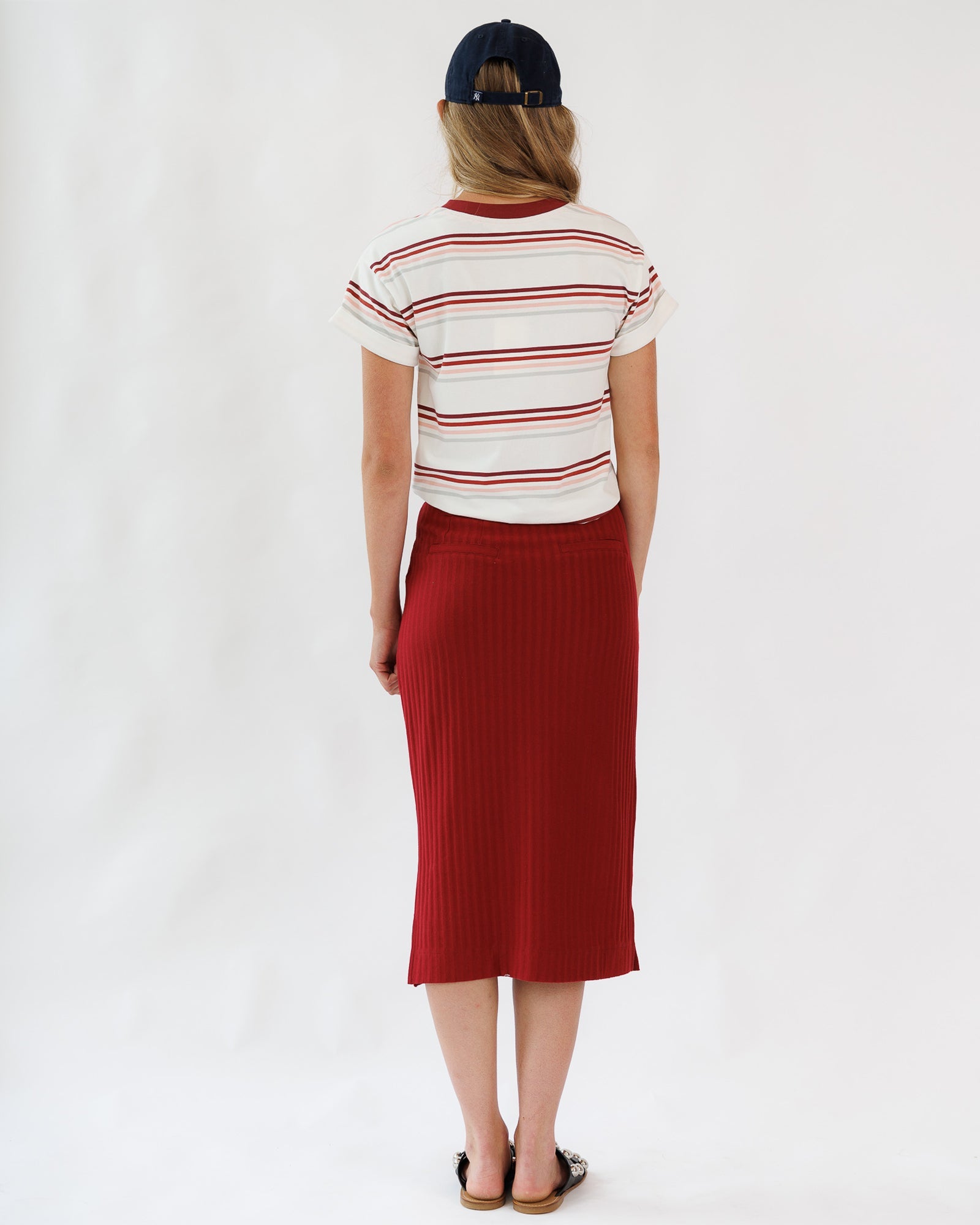 Person wearing a striped shirt and red skirt on a white background