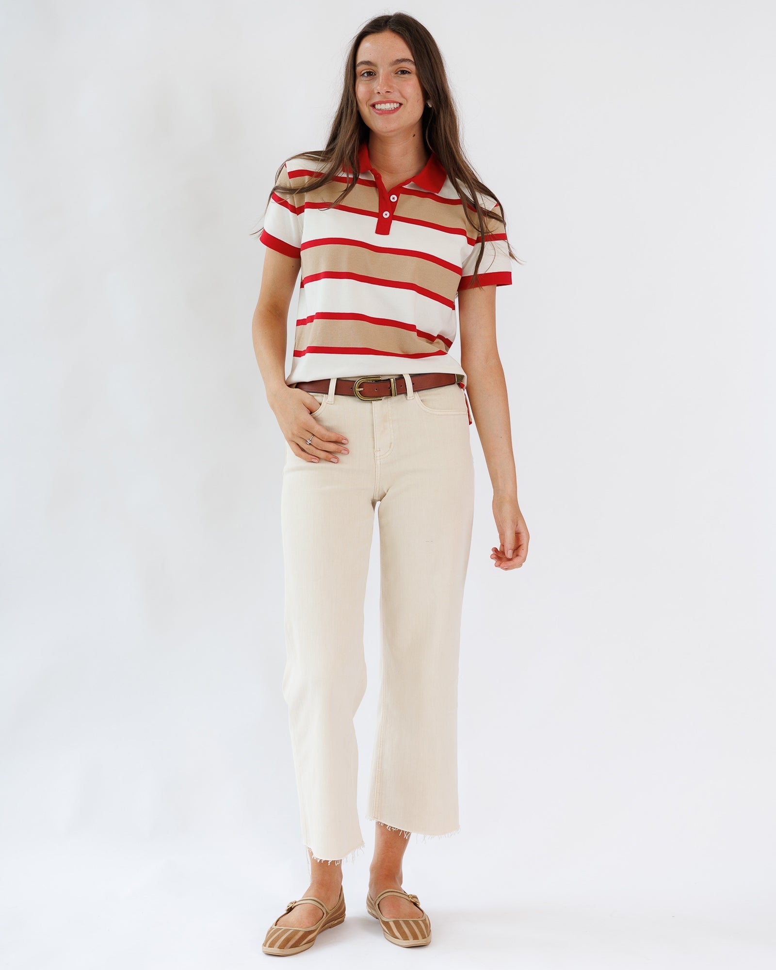 Woman wearing a striped shirt and beige pants on a white background