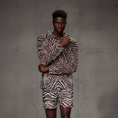 Person wearing a zebra print outfit against a gray background