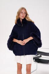 Woman wearing a navy blue coat with fur trim on a white background