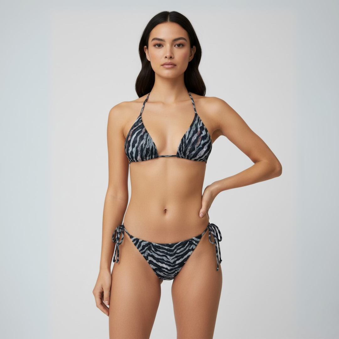 Woman wearing a black and white patterned bikini against a plain background
