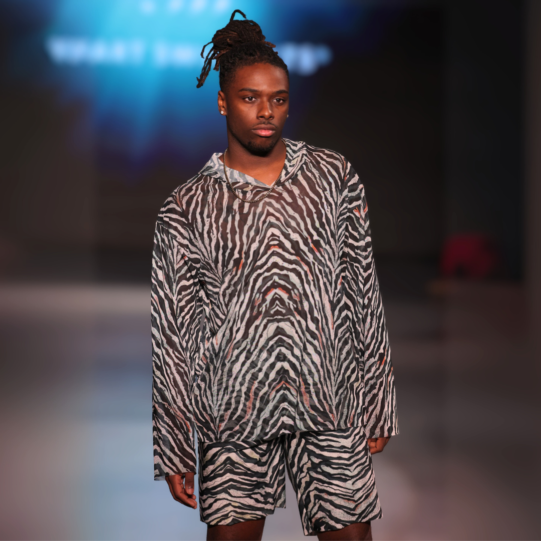 Model wearing a zebra-striped outfit on a runway with a blurred background
