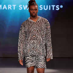 Model wearing a zebra print outfit on a runway with 'Smart Swimsuits' branding.