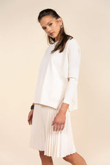 Woman wearing a white outfit with a beige background