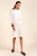 Woman wearing a white dress with a plain background