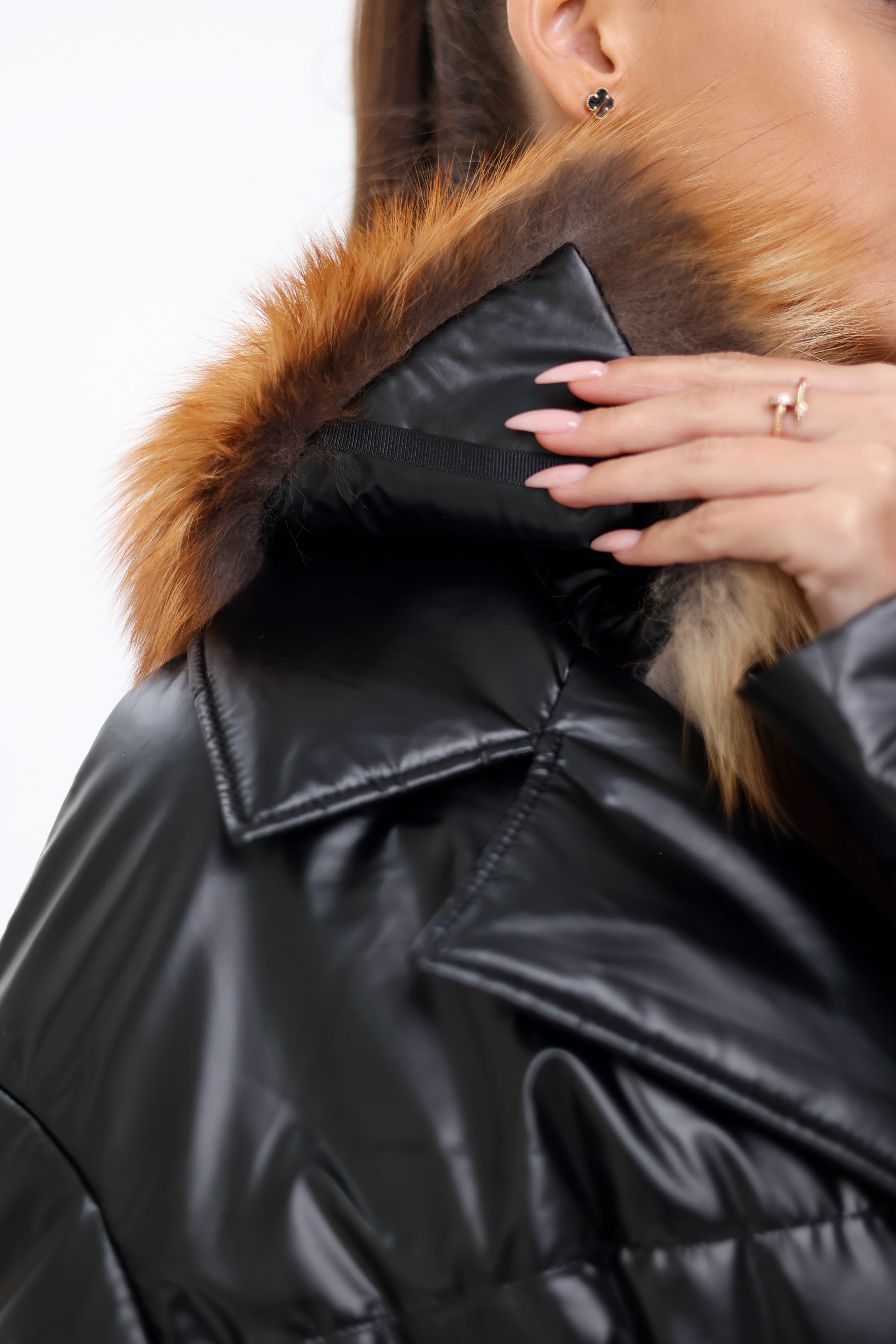 Black puffer jacket with fur hood on a white background
