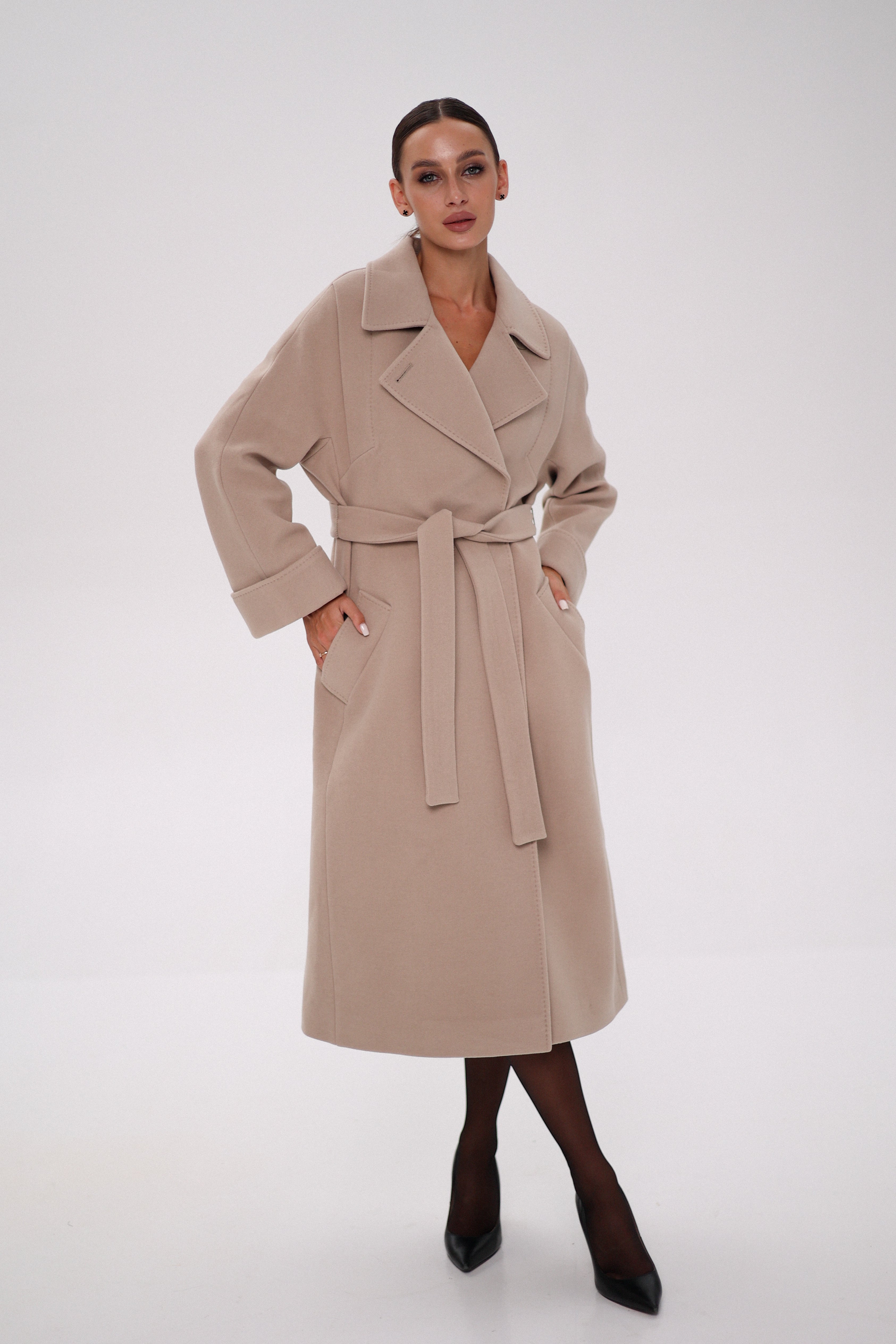 Woman wearing a beige trench coat on a white background