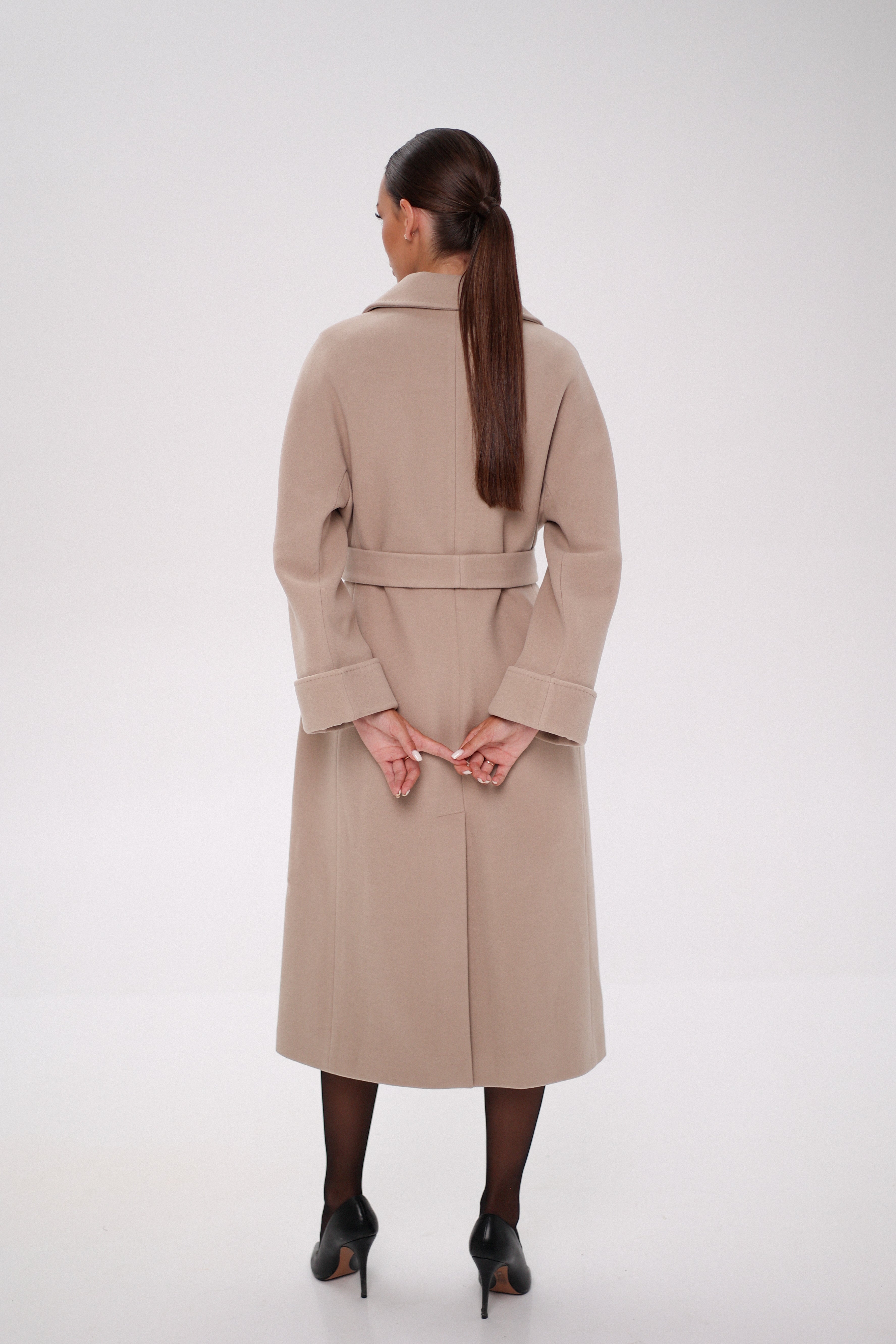 Woman wearing a beige trench coat on a white background