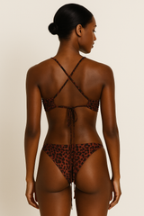 Model wearing a leopard print swimsuit with a beige background
