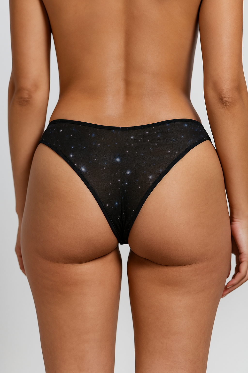 Black star-patterned underwear worn by a person on a neutral background