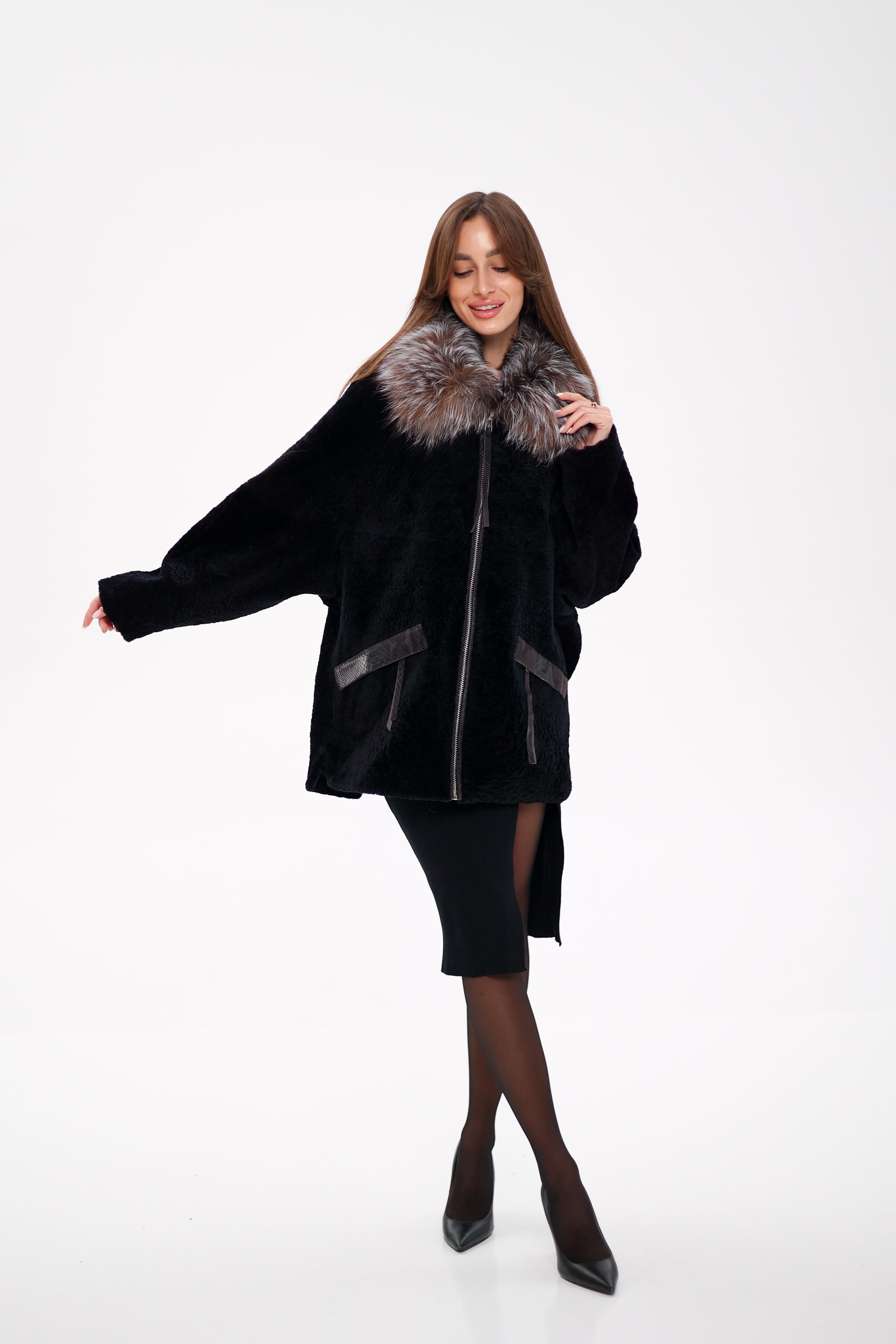 Woman wearing a black coat with fur trim on a white background