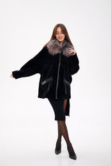 Woman wearing a black coat with fur trim on a white background