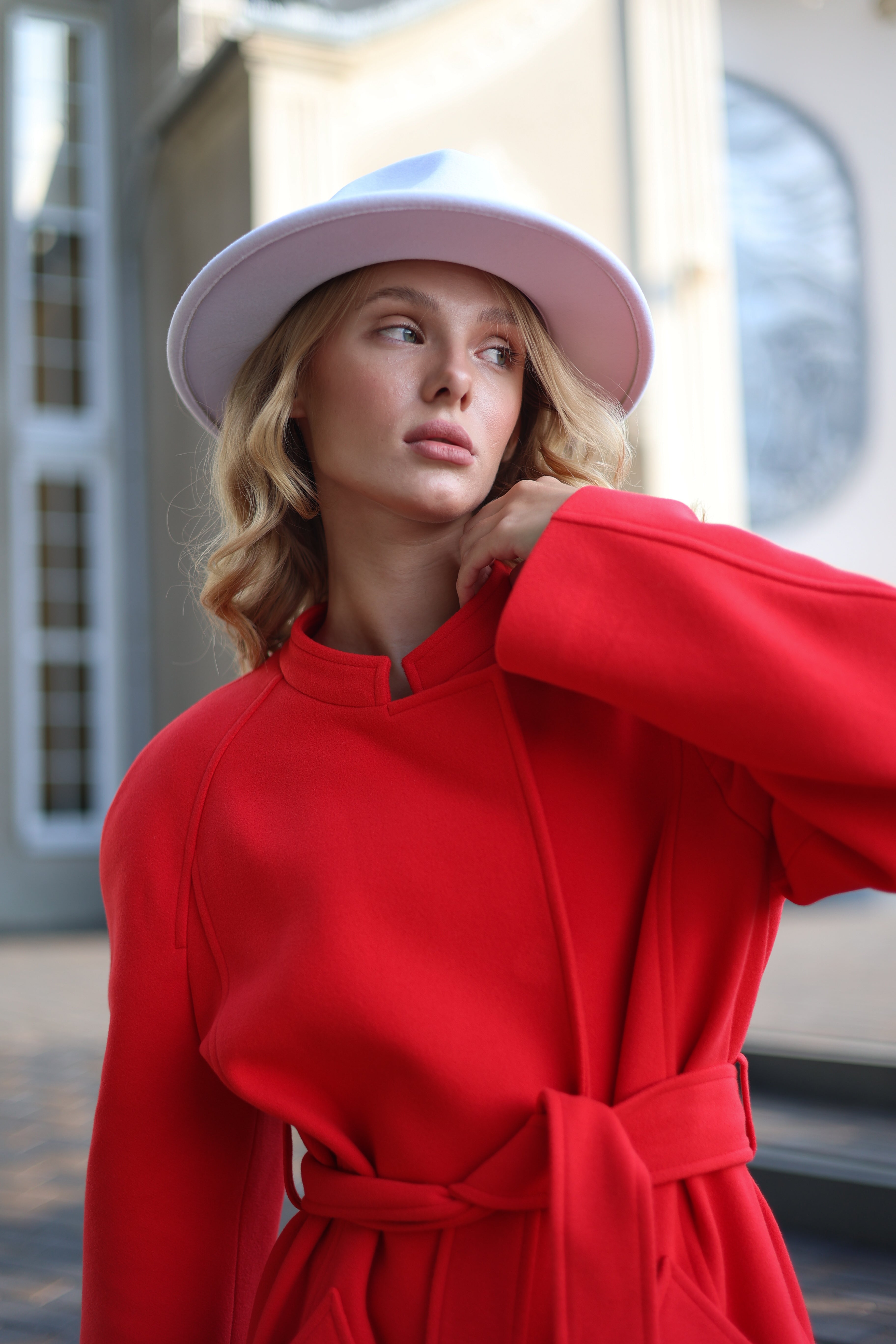 Woman wearing a red coat and pink hat outdoors