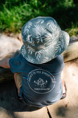 Child wearing a patterned hat and t-shirt with 'Nature is my playground' text outdoors.