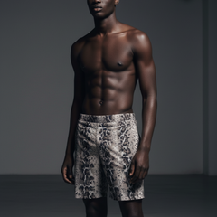 Man wearing patterned shorts against a dark background