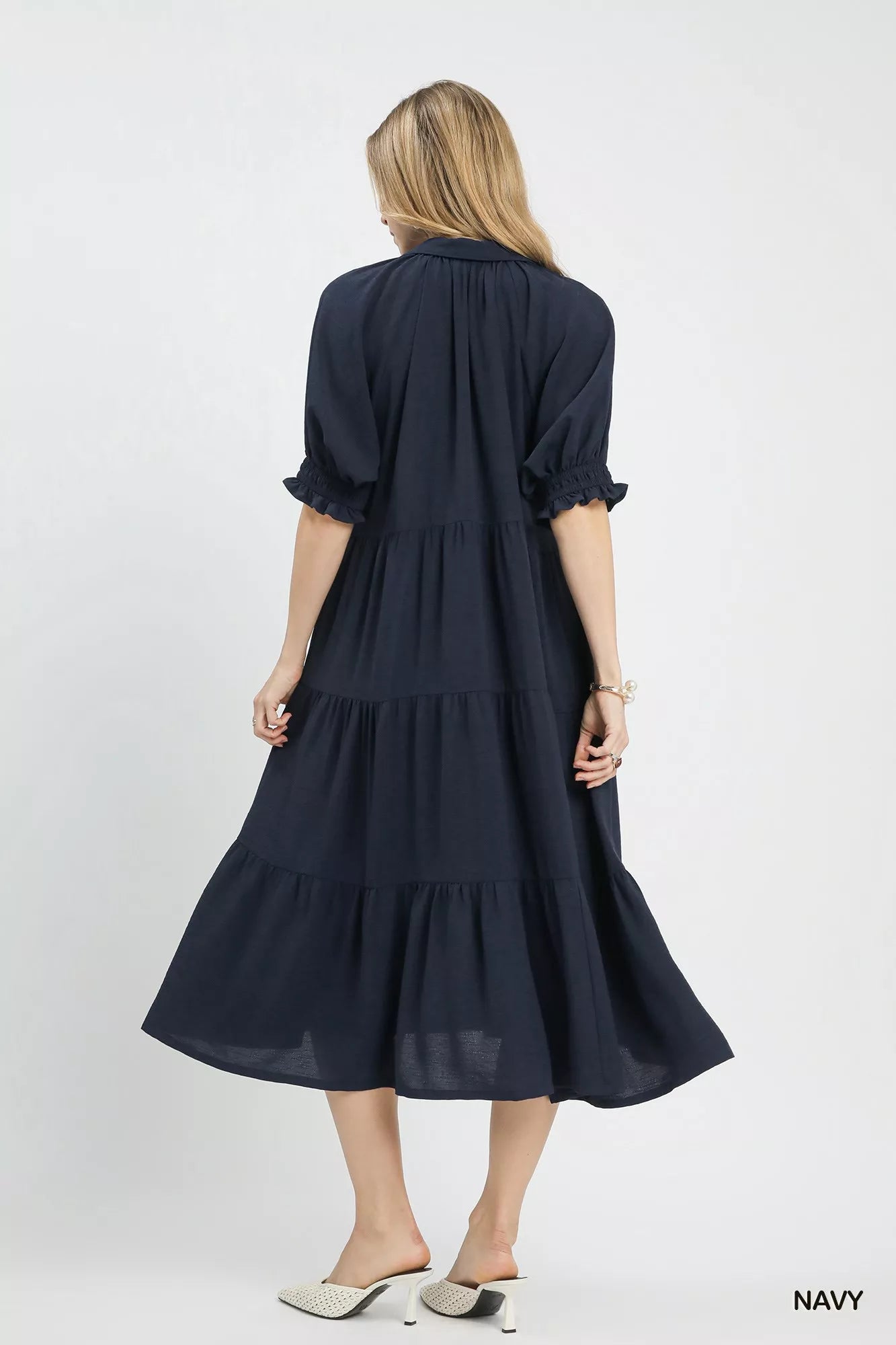 Woman wearing a navy dress on a white background