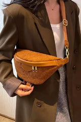 Person wearing a brown coat holding a brown waist bag.