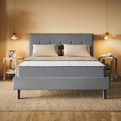 Gray upholstered bed with a mattress in a bedroom setting.