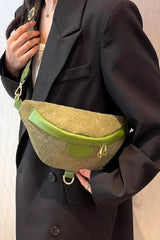 Person wearing a dark coat holding a green and beige bag.