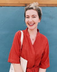 Woman in a red outfit standing against a blue wall
