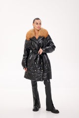 Person wearing a black puffer coat with a fur collar on a white background