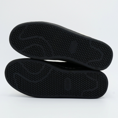 Black shoe soles on a light gray background