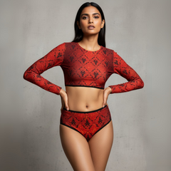 Woman wearing a red patterned long-sleeve top and high-waisted underwear against a gray background
