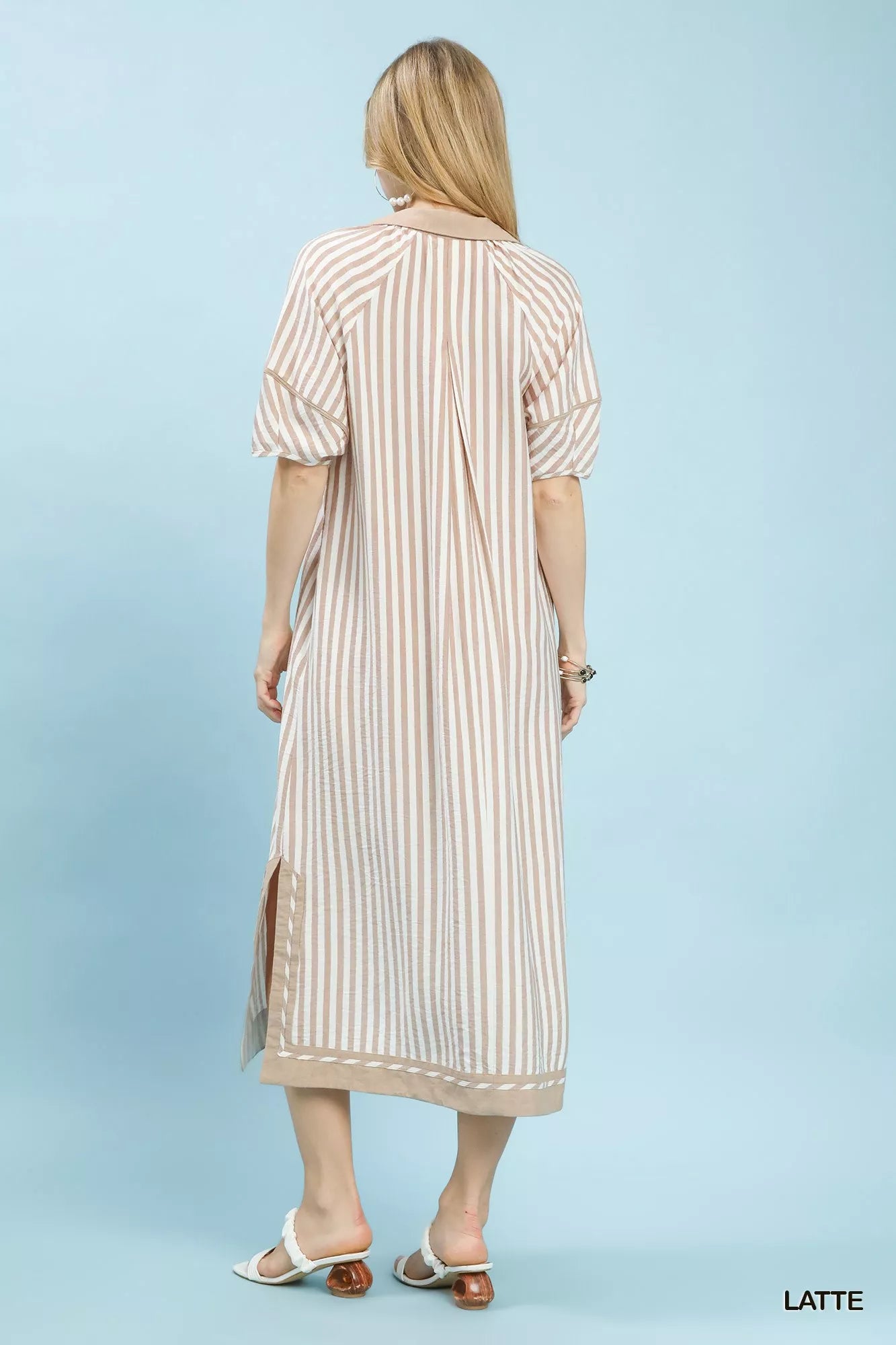 Woman wearing a striped dress on a light blue background