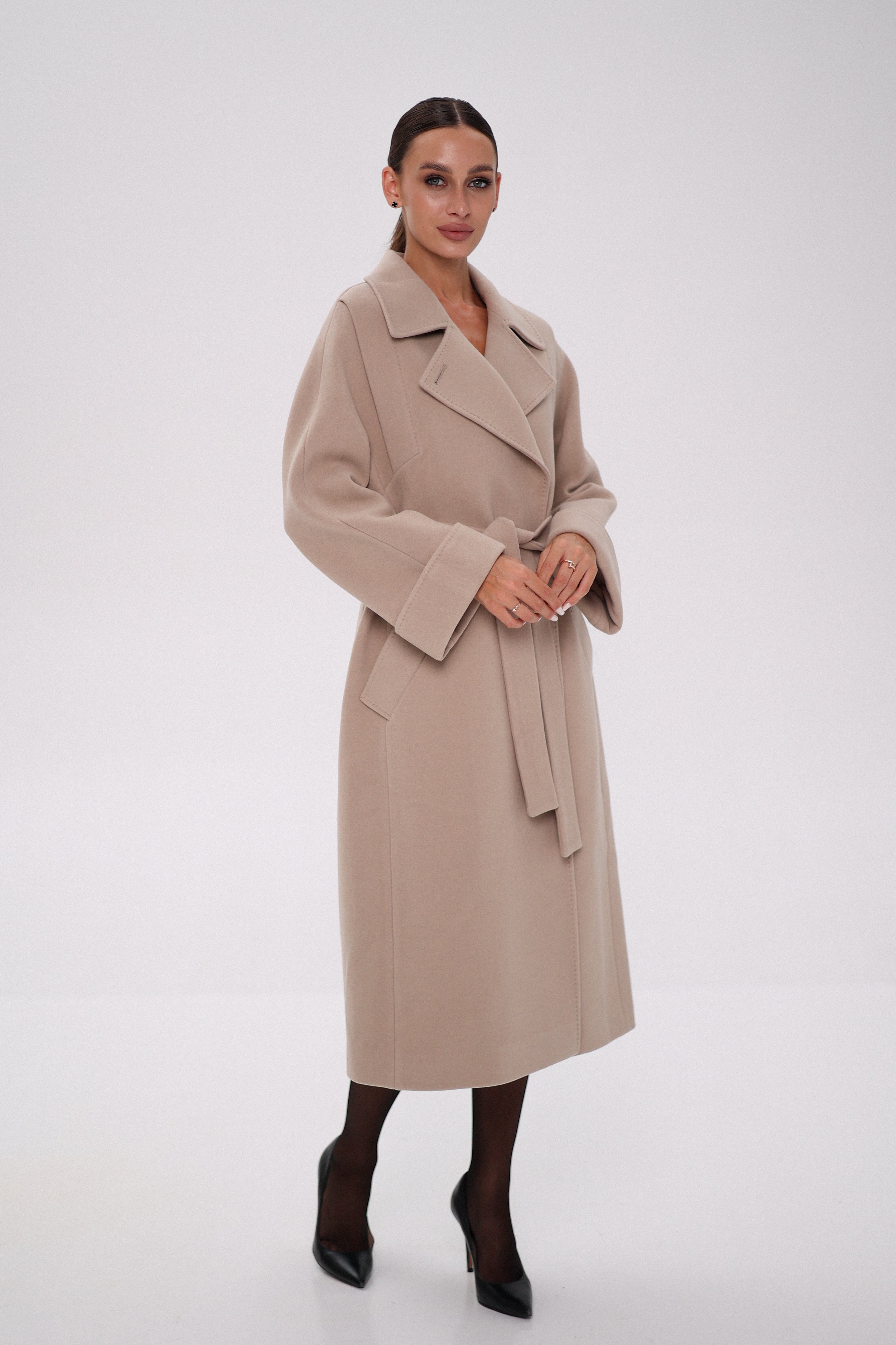 Woman wearing a beige trench coat on a white background