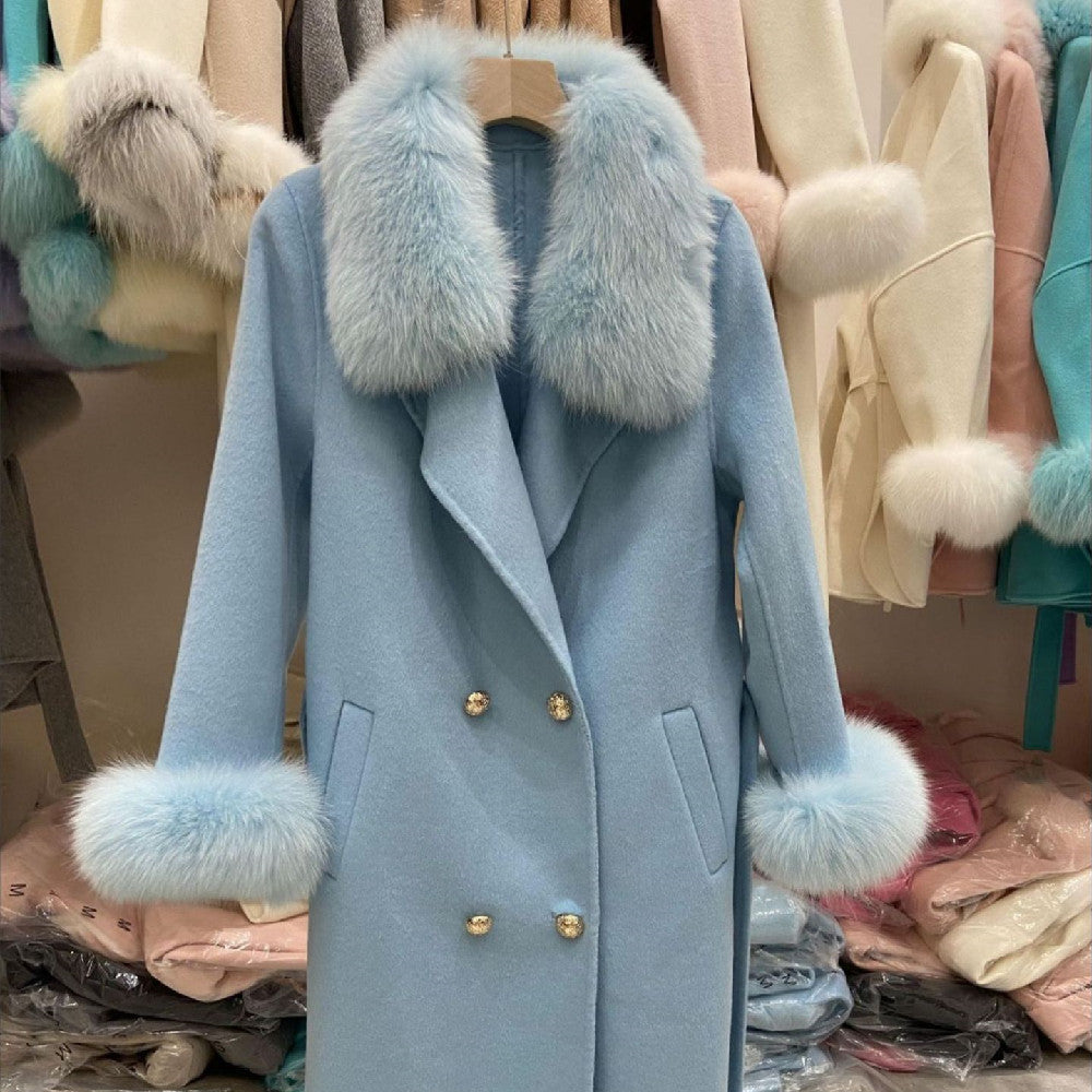 Blue coat with fur trim hanging on a rack among other coats.