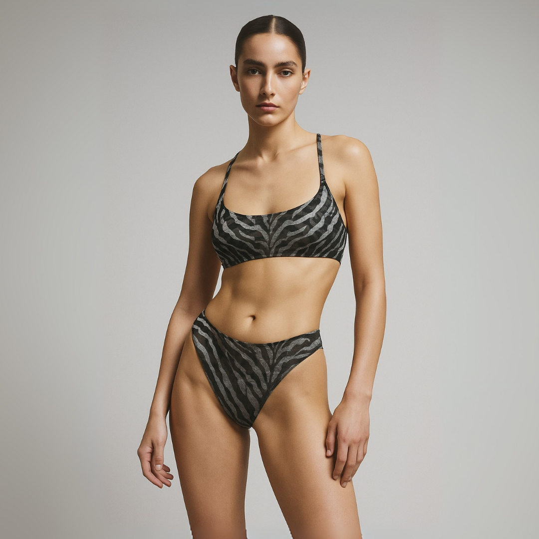 Woman wearing a black and white zebra print bikini against a gray background