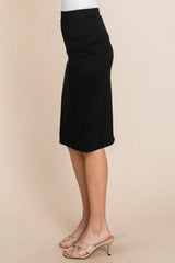 Black pencil skirt worn by a person on a beige background