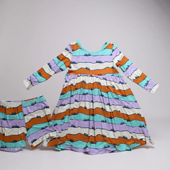 Colorful striped dress and bloomers set on a gray background