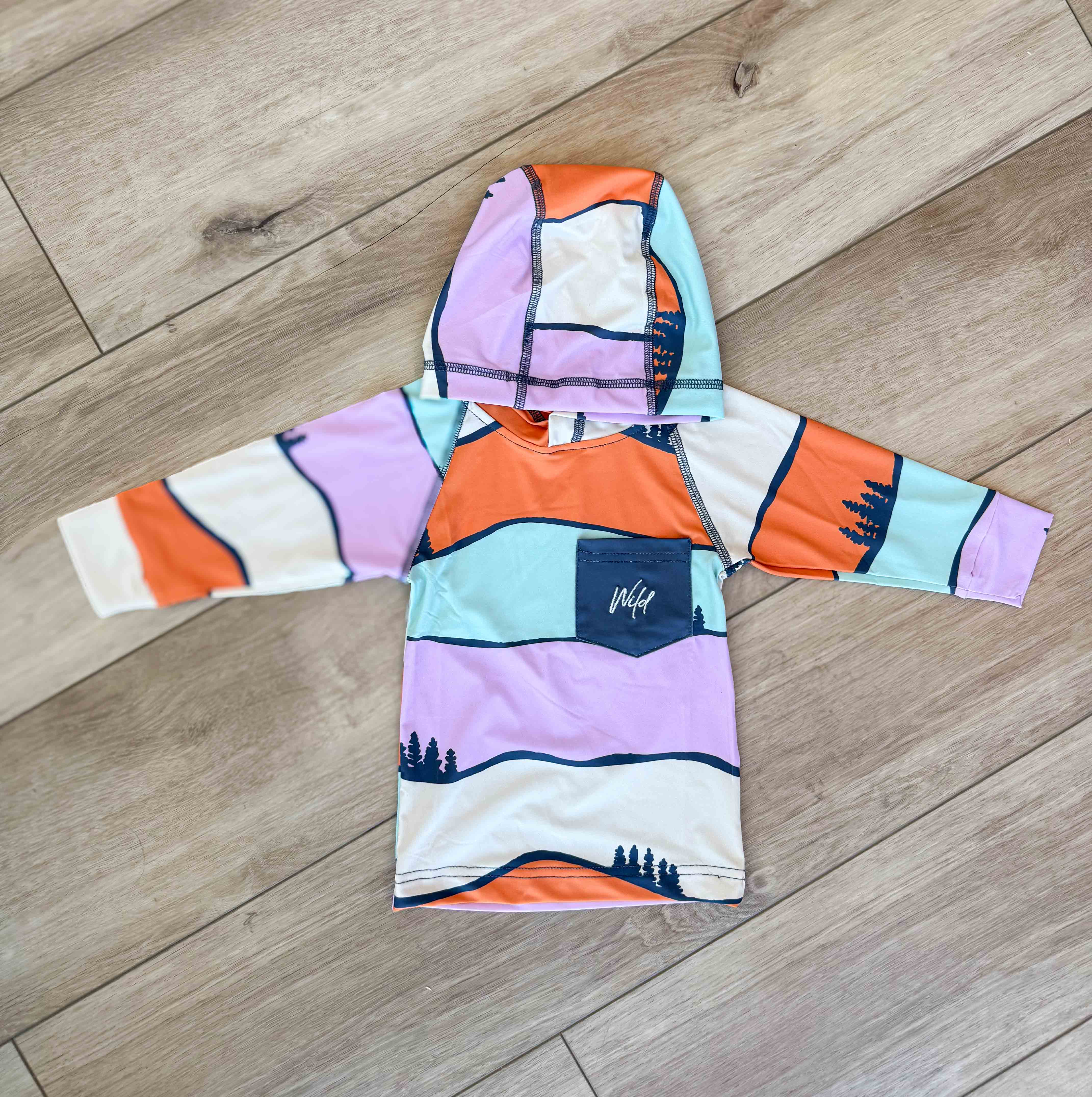 Colorful hoodie with abstract design on a wooden floor