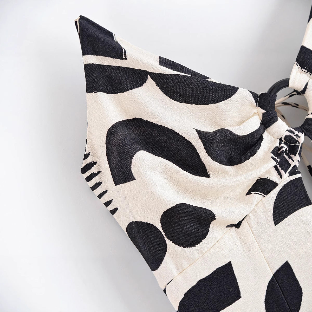 Black and white patterned bikini top on a light gray background