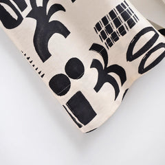 Fabric swatch with black abstract patterns on a beige background