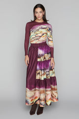 Woman wearing a long, multicolored dress with a blurred background