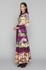 Woman wearing a long, multicolored dress with a gray background