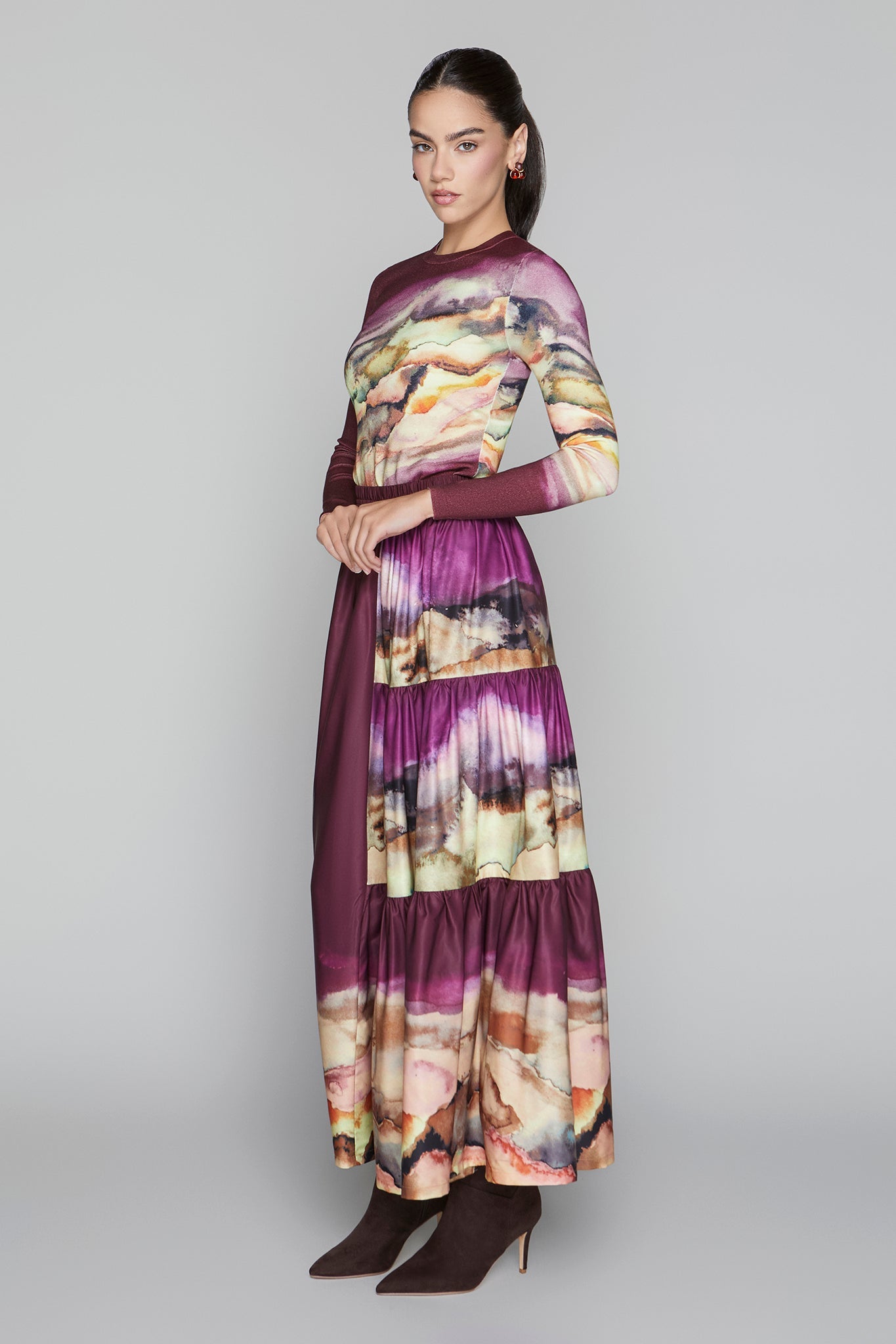 Woman wearing a long, patterned dress on a gray background