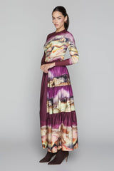 Woman wearing a long, patterned dress on a gray background