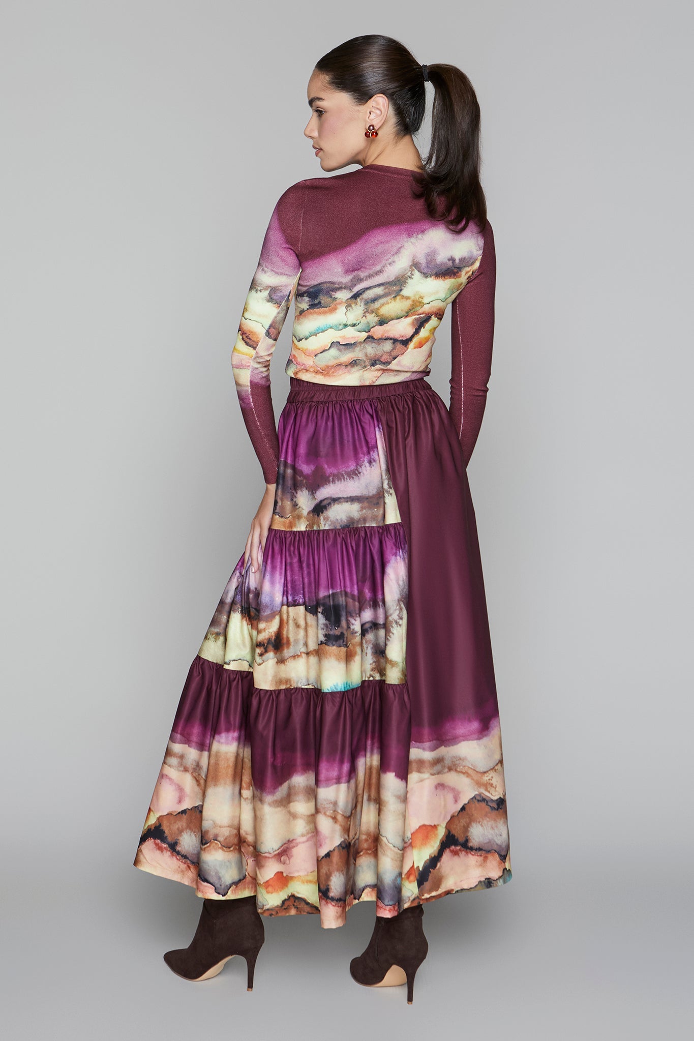 Woman wearing a long, patterned dress with a neutral background